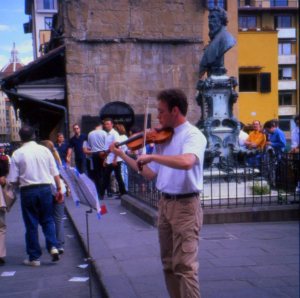 Musician plays for tips on the Ponte Vecchio, Florence, Italy.